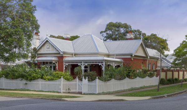 House With Matching White Roof And White Picket Fence