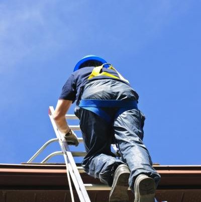 Worker With Safety Harness Climbing To The Roof